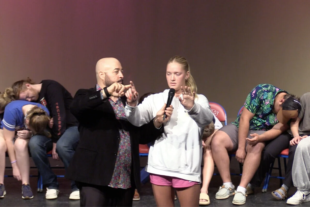 Student on stage during a hypnosis performance